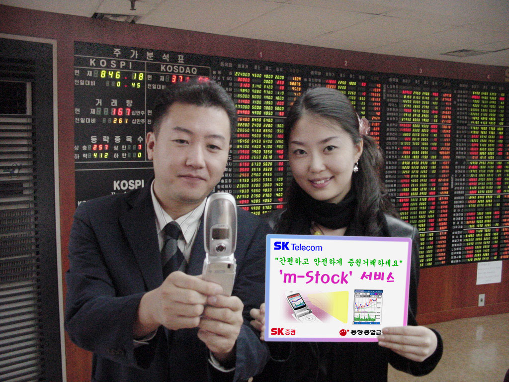 SK Telecom customers are shown doing stock trading through the `m-Stock` service. (An SK Telecom`s chip based mobile stock trading service called `m-Stock` will be introduced starting on October 18th. This represents a first in the financial industry)